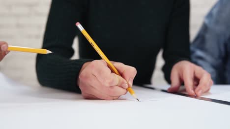 Happy-diverse-group-of-students-or-young-business-team-working-on-project.:-they-are-drawing-a-plan-using-pencil-and-ruler