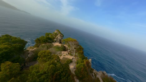 Fpv-drohne-Fliegt-Auf-Mallorca,-Fliegt-Tief-über-Bäume-Und-Taucht-Die-Hügel-Am-Ufer-Hinunter,-Fliegt-In-Der-Abendsonne-über-Den-Ozean