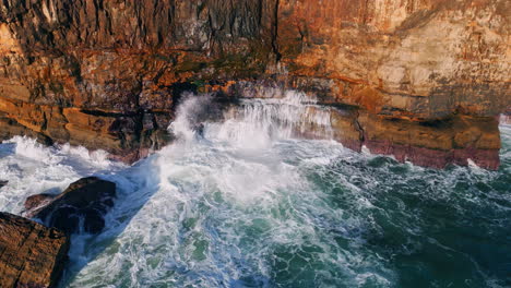 stormy waves white foam crashing coastal rocks. aerial sea water breaking stone