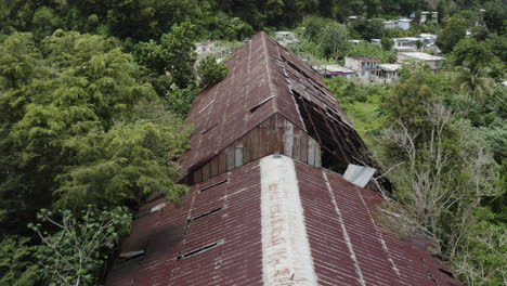 an abandoned and rusted old warehouse in los canos puerto rico has fallen into a state of disrepair and is slowly disappearing into the surrounding jungle