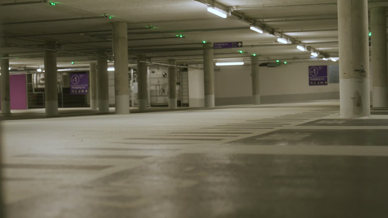 Lights becoming bright in empty underground parking lot in Metzingen, Germany, Baden Wurttemberg, Europe, panning view angle
