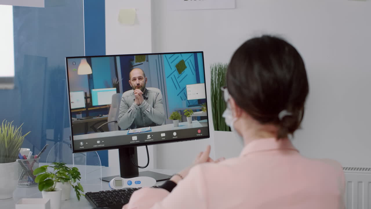 Freelancer with protection face mask talking with executive manager on computer