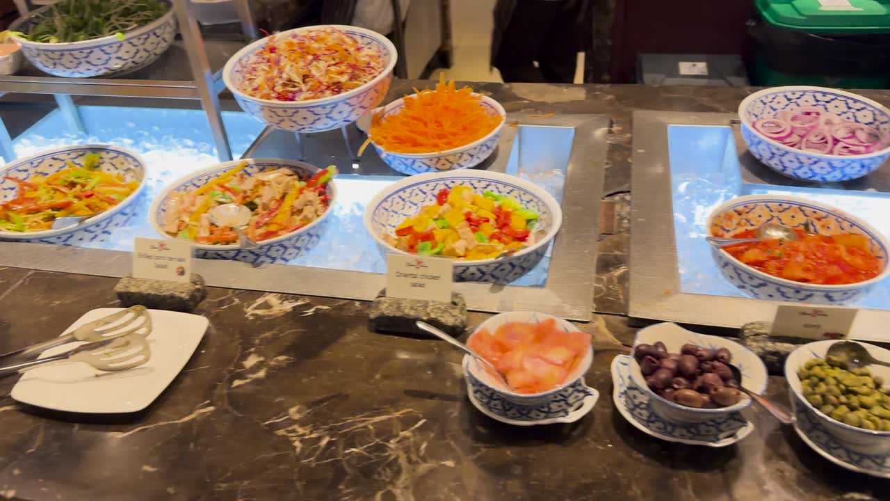 A vibrant buffet display with diverse dishes at a resort restaurant in Phuket, Thailand, captured under warm lighting
