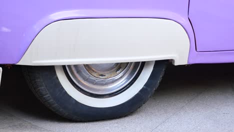 close-up of a vintage car's purple fender and whitewall tire