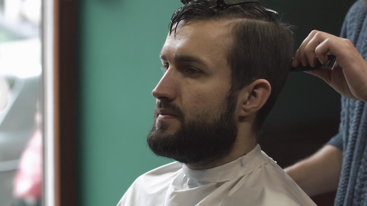 un hombre recibiendo un corte de pelo en una barbería