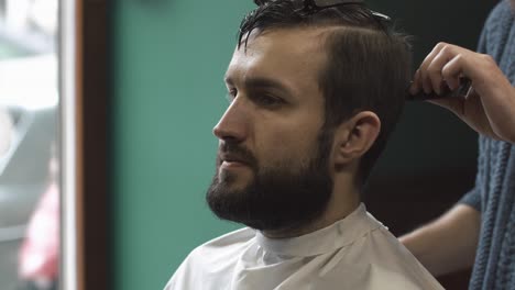 a man getting a haircut at a barber shop