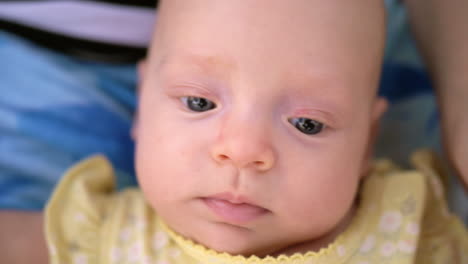 blue-eyed baby girl in yellow onesie