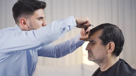 the man in need of care is getting his hair cut in his home.