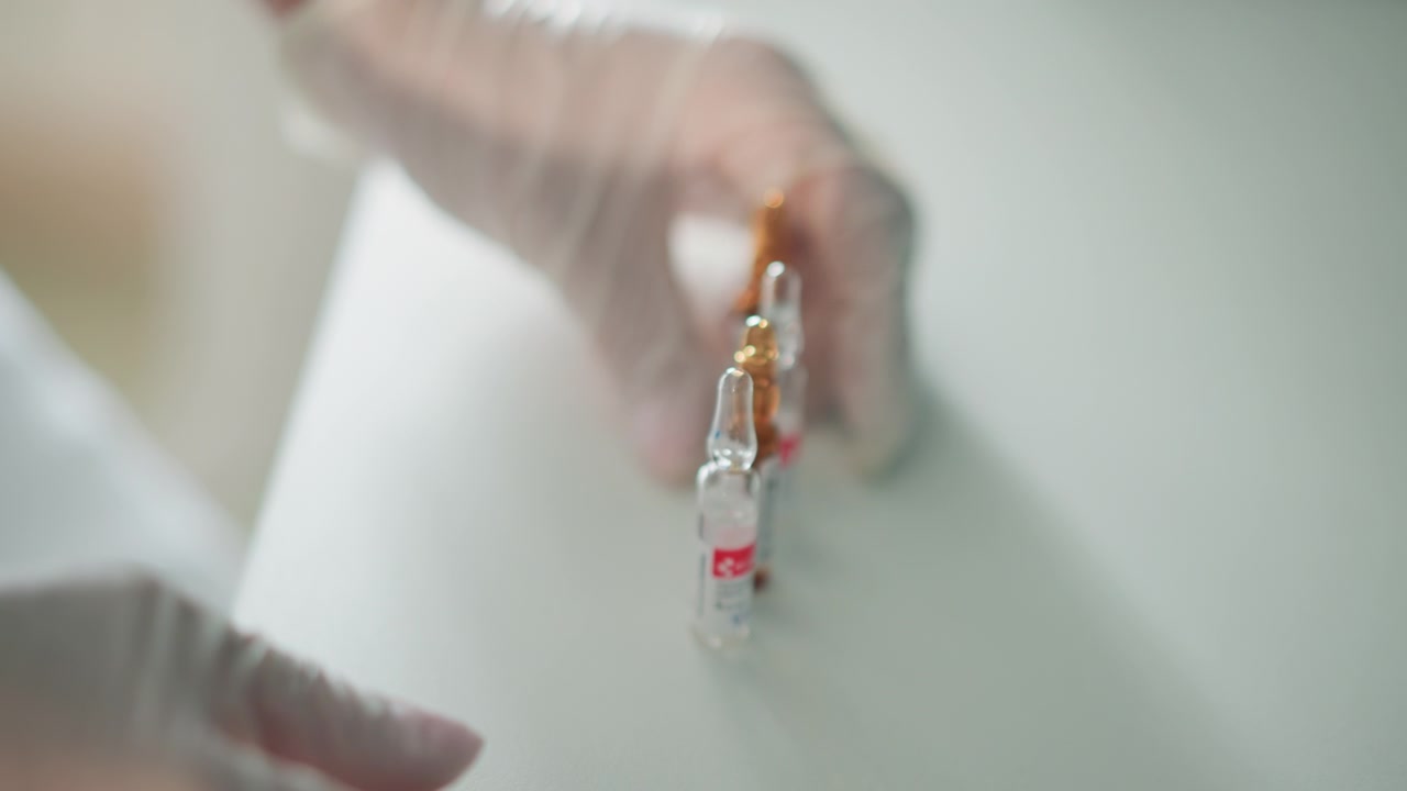 Healthcare workers prepare drugs. Medical staff carefully organize medication containers. Medical personnel methodically organize all medication bottles and ampoules before beginning procedures