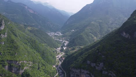 The-road,-river,-and-village-between-the-two-mountains