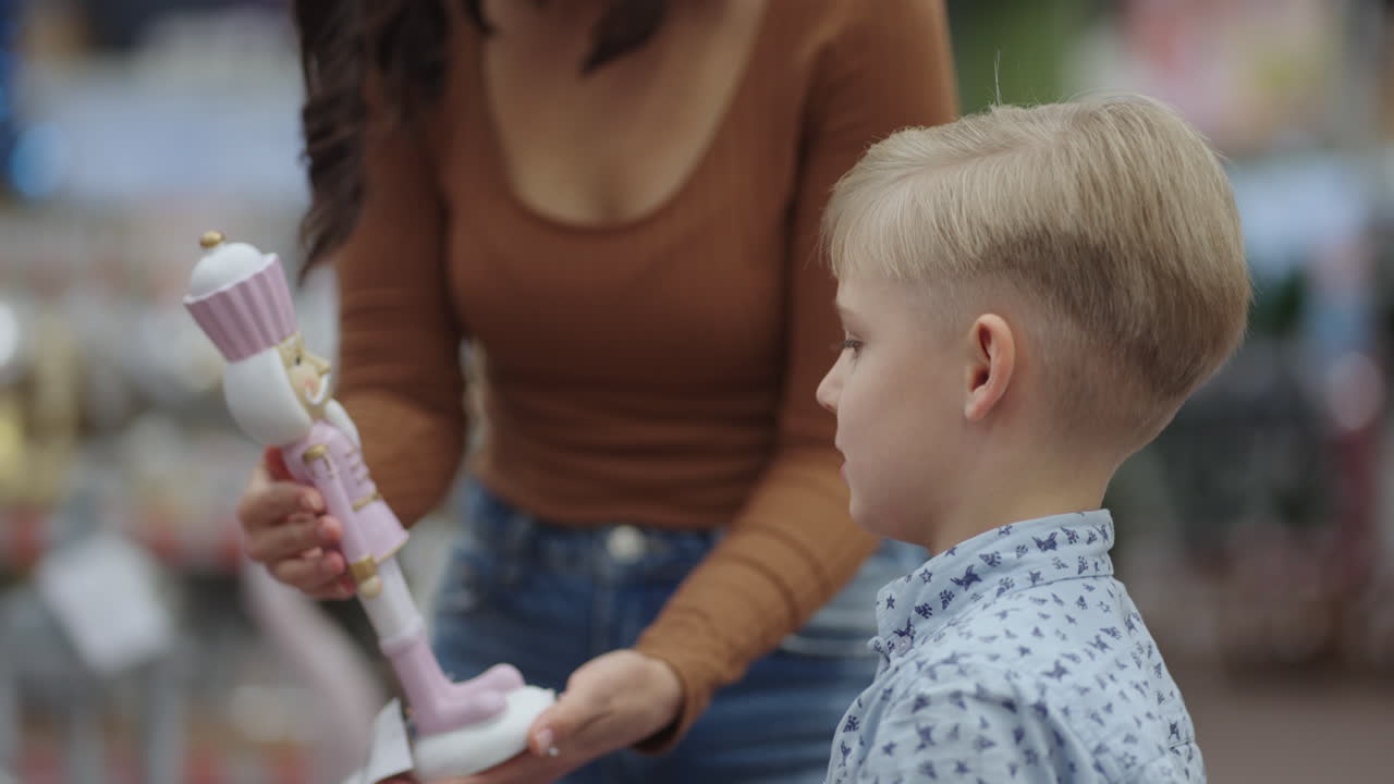 comprando en una mujer pandémica con mascarilla y su hijo está eligiendo juguetes en una tienda para niños, una madre joven está comprando productos en un supermercado para prevenir enfermedades virales