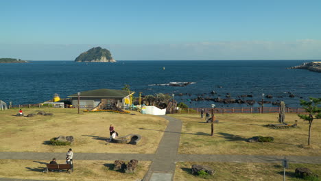 位於韓國西<unk>島 (seogwipo) 的捷<unk>海岸公園 (jaguri coast park) 的一個陽光明<unk>的日子