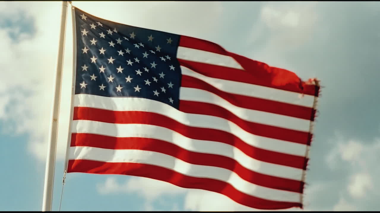 Bandiera americana che sventola al vento contro un cielo nuvoloso
