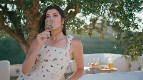 smiling model holding glass drink enjoying under tree closeup. lady drinking