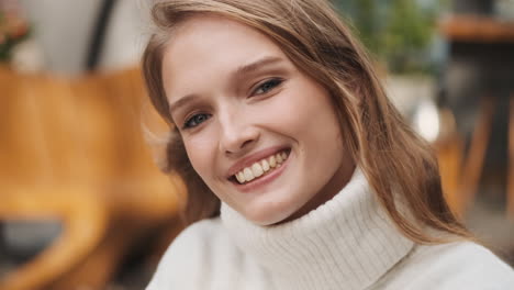 una mujer caucásica sonriendo a la cámara.