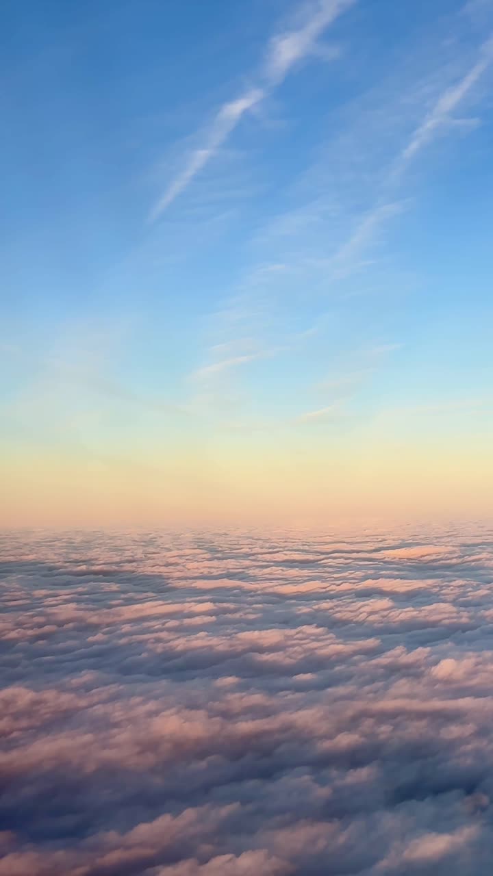 Tenui tonalità pastello del tramonto illuminano le nuvole sotto un vasto cielo blu. Ideale per promozioni di viaggio o contenuti ispirazionali