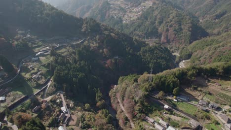 Fly-over-the-mountains-of-Shikoku-in-autumn-and-the-road-leading-to-it,-with-the-red-foliage-in-Japan