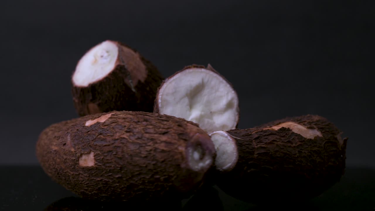 4K rotating close-up of cassava root (yuca, manioc, tapioca) with rough skin. Ideal for projects on tropical cuisine, exotic ingredients, organic farming, gluten-free diets, and superfoods