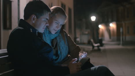 Couple-Sitting-on-the-Bench-with-Tablet