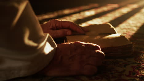 man reads a holy book for ramadan on the carpet