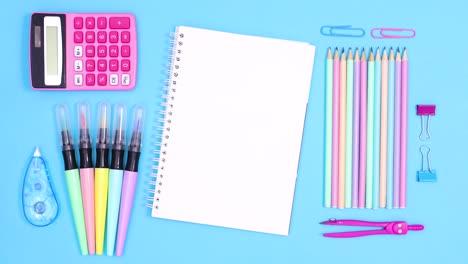 open notebook for text move on blue theme with ordered back to school accessories. stop motion