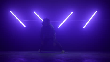 agile breakdancer performing dance on nightclub. young man making spinning moves