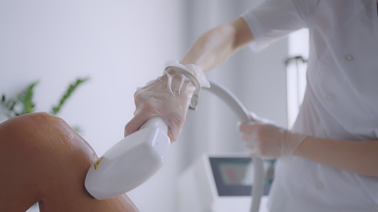 미용실에서 레이저 탈모와 화장품. 화장품 스파와 탈모 개념. 여성 다리의 레이저 탈모 절차. 장갑을 입은 의사.