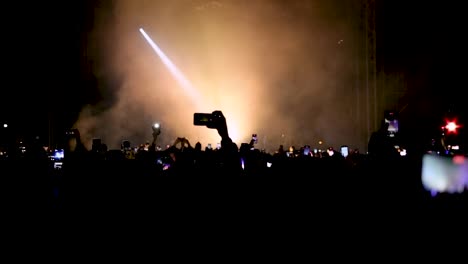 crowd enjoying live performance and taking videos with smartphones