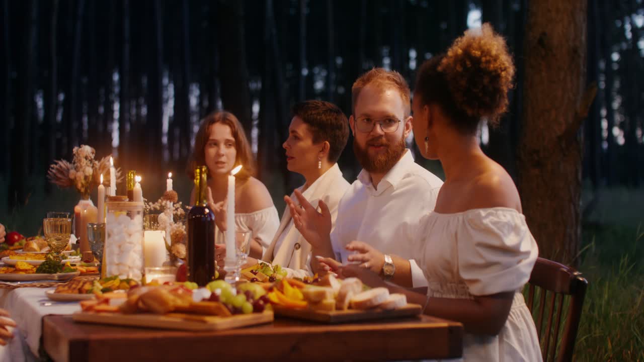 amigos disfrutando de la cena en un bosque