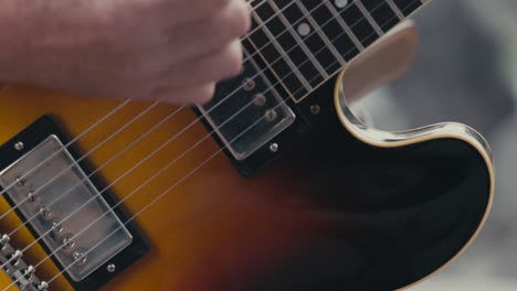 guitarist hand strumming electric guitar. - close up