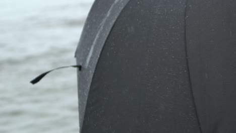 girl with umbrella on beach slow motion in the rain