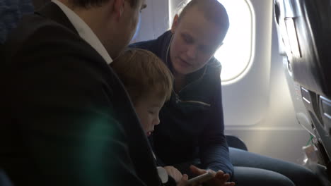 child and young parents traveling by plane