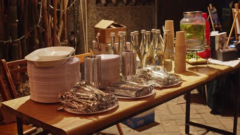 drinks, cutlery and plates prepared on the table for outdoor event