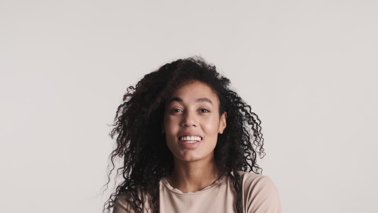mujer afroamericana alegre sobre fondo blanco.