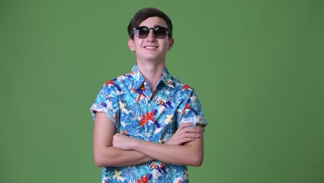 young handsome iranian teenage boy ready for vacation against green background