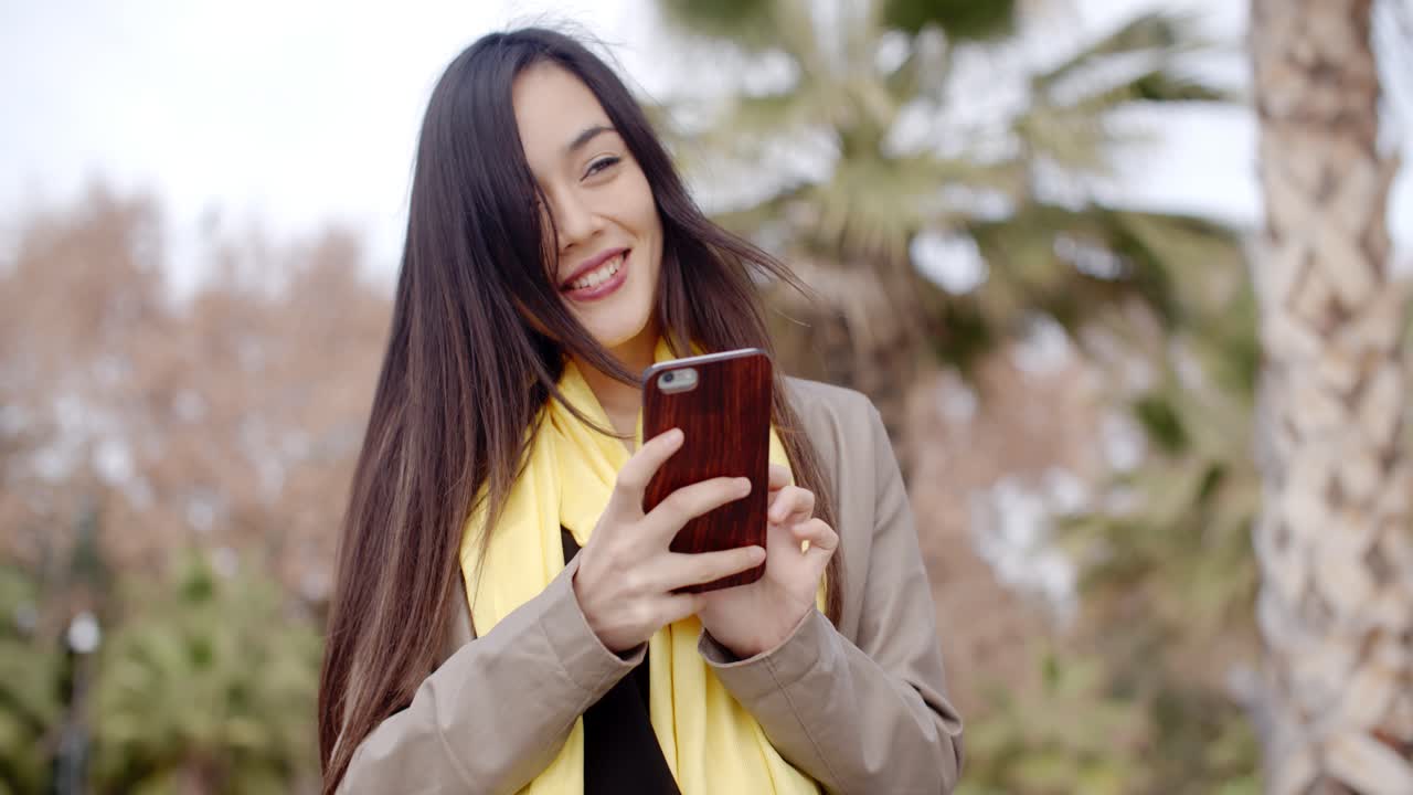 Giovane donna felice che invia un messaggio di testo