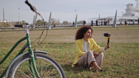 woman vlogging outdoors with bicycle and cruise ship in background