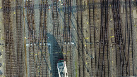 top down aerial view of train on one of many tracks in central station