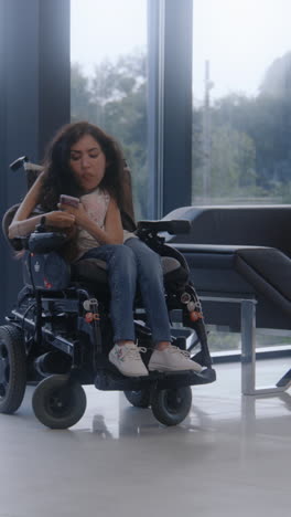mujer en silla de ruedas usando teléfono móvil