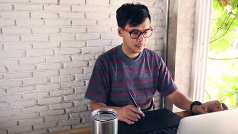 hombre diseñador gráfico trabajando con su computadora portátil, teclado y tableta
