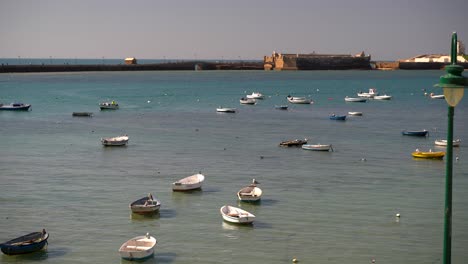 many small fishing boats in ocean during high tide in cadiz bay