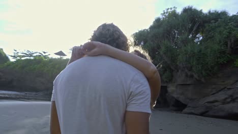 una pareja besándose suavemente en la playa.