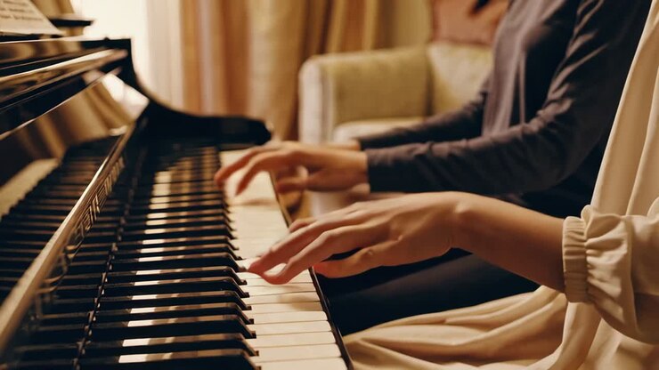 Two people playing piano