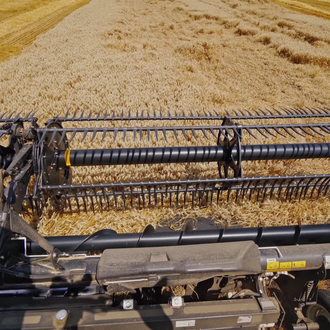 Metal detail of combine harvester. Modern combine harvesting wheat on the field in summer. View from agricultural machine. Close-up.
