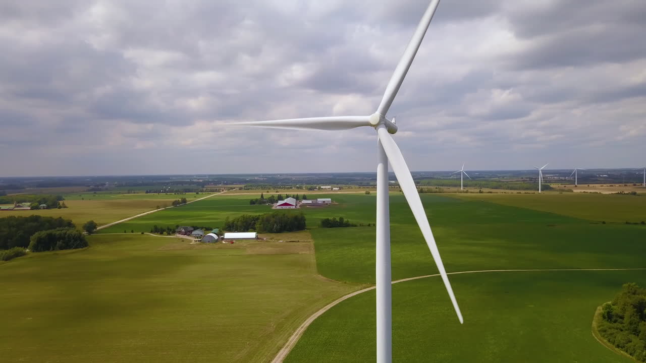 Aerial circling a wind turbine on an overcast summer day