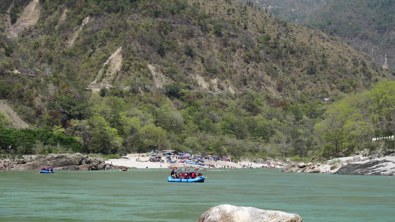 View of Rishikesh from Tapovan riverside in Morning with tourist rafting boats sailing on Ganga river.