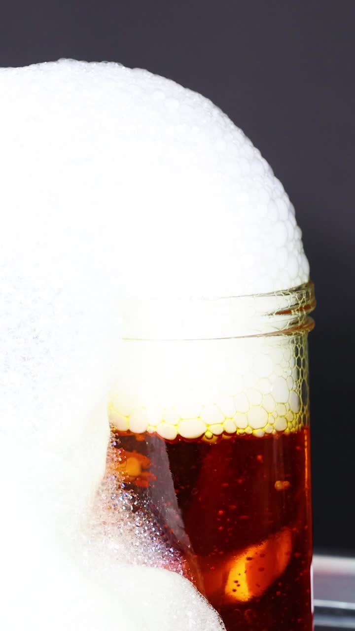 Vibrant dry ice bubbles overflow from jars, creating a mesmerizing science experiment with colorful liquids and dynamic foam