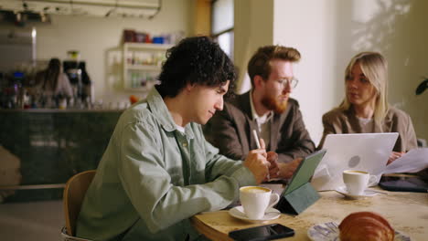 three people working together at a coffee shop