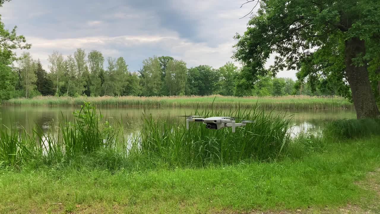 imágenes de un video filmando un pequeño dron volando en la naturaleza a baja altura sobre el suelo