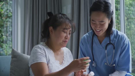 smiling asian female doctor talking to happy female patient about her medication at hospital